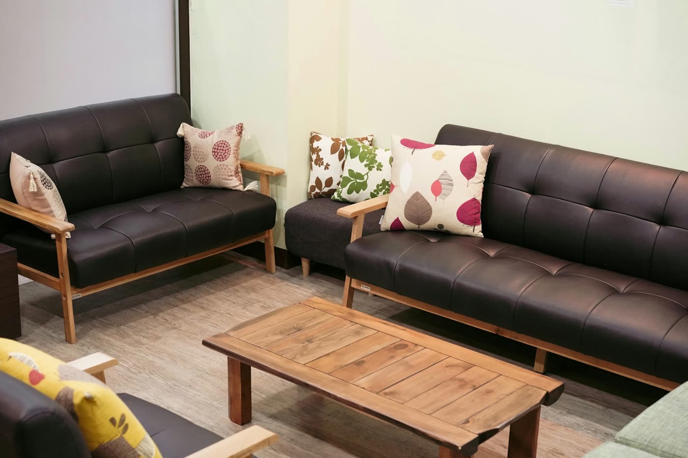 The waiting room of the Seoul clinic in Itaewon: two leather sofas with patterned cushions and a wooden coffee table