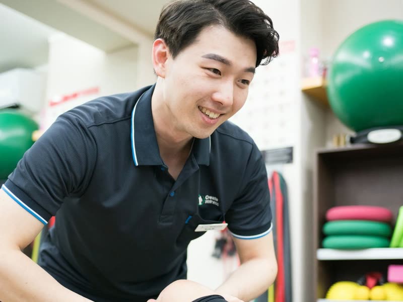 Rehabilitation therapist guiding a patient through a knee exercise at Create Wellness Center